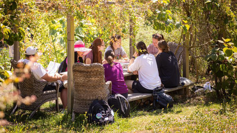 trailhead students sitting around a table in the garden