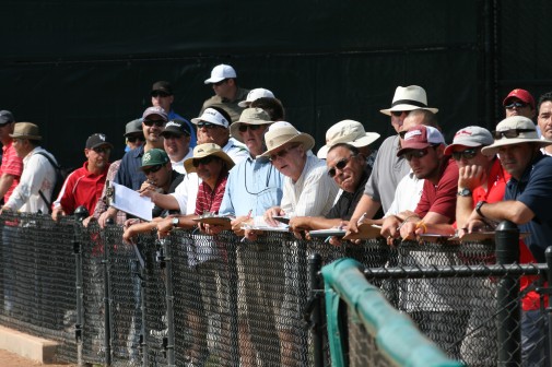 Pro scouts and coaches watch from the bullpen during tryouts