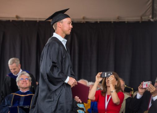 Tracy Lehr and John Palminteri snap photos as Connor McMannigal walks across the stage with his diploma