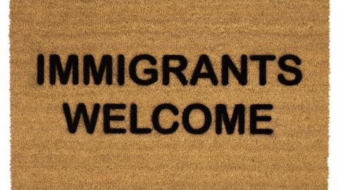 Doormat that reads "Immigrants Welcome."